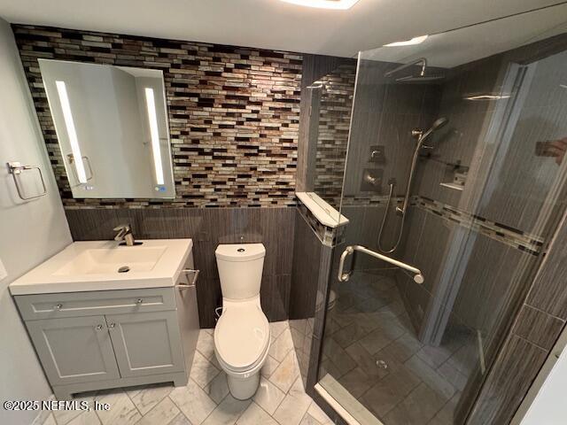 bathroom with vanity, tile walls, an enclosed shower, and toilet