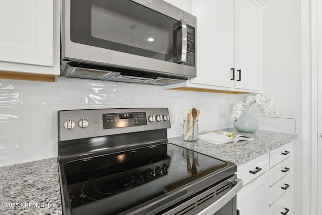 kitchen featuring light stone counters, backsplash, stainless steel appliances, and white cabinets