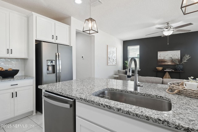 kitchen with stainless steel appliances, sink, decorative backsplash, and white cabinets