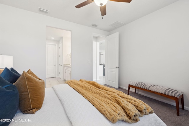 tiled bedroom with ensuite bathroom and ceiling fan