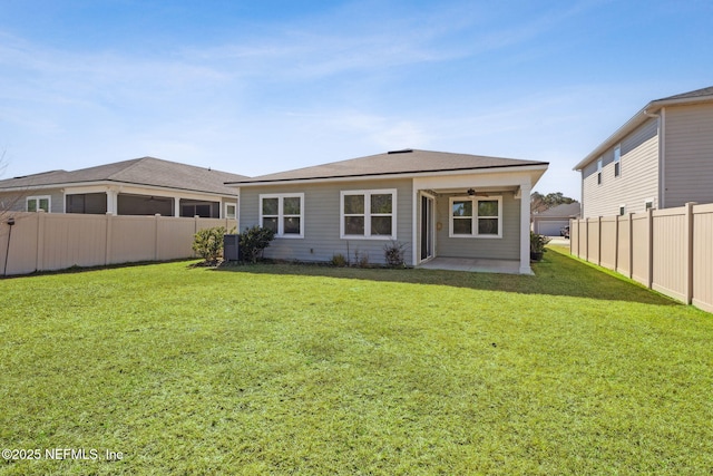 back of property with central AC, a patio area, and a lawn