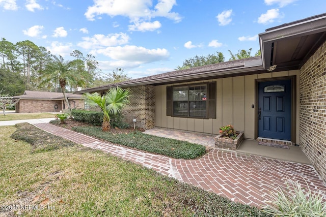 property entrance with a lawn