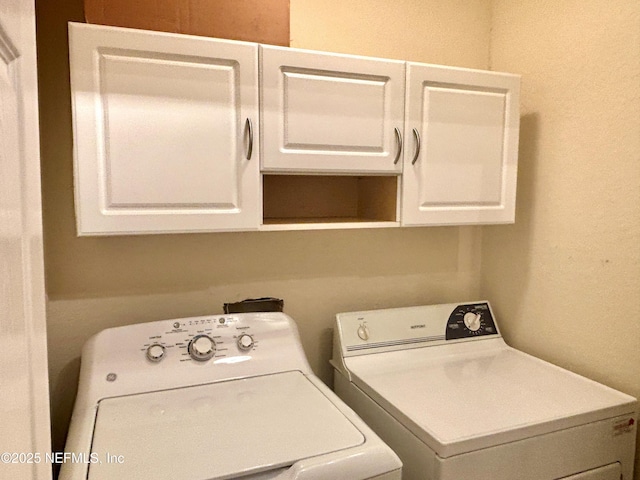 washroom featuring cabinets and washing machine and dryer