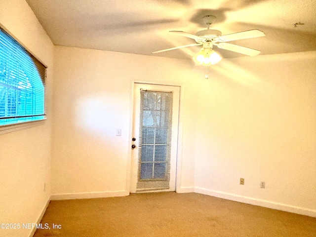 carpeted spare room featuring ceiling fan