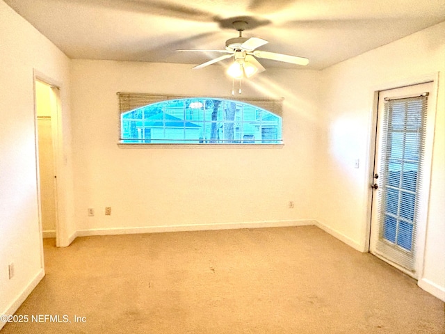 spare room featuring light carpet and ceiling fan