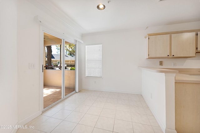 unfurnished dining area featuring light tile patterned floors and baseboards