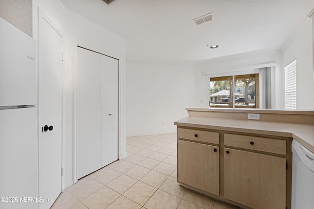 kitchen featuring light tile patterned floors, light countertops, visible vents, ornamental molding, and white appliances