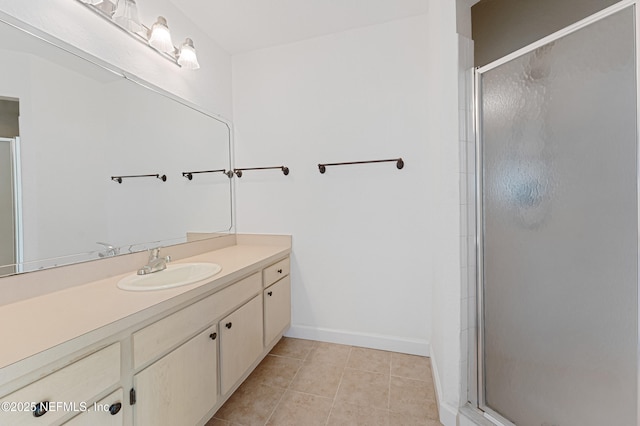 full bath featuring baseboards, a stall shower, vanity, and tile patterned floors