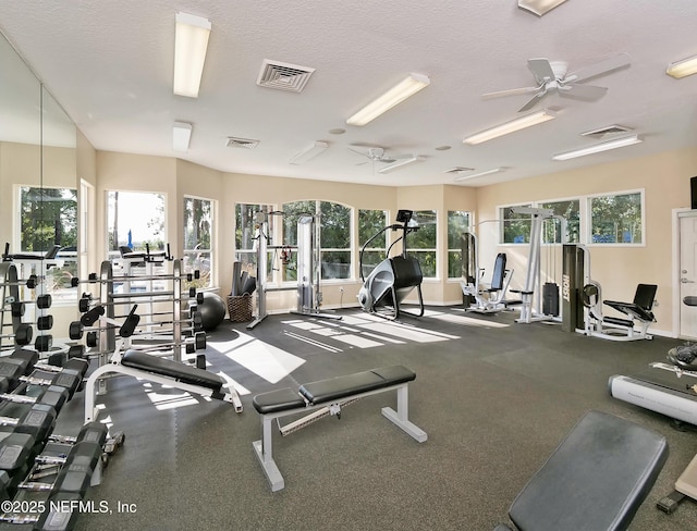 exercise room featuring visible vents, ceiling fan, a textured ceiling, and baseboards