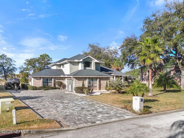 view of front of property featuring a garage and a front lawn