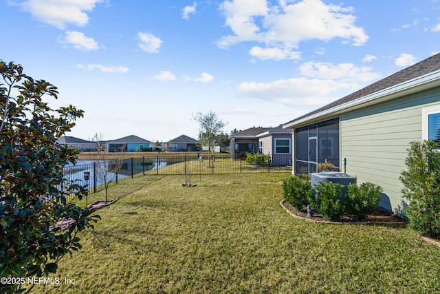 view of yard with central AC, a sunroom, and a water view