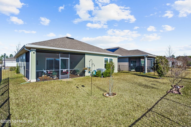 rear view of house with a sunroom and a yard