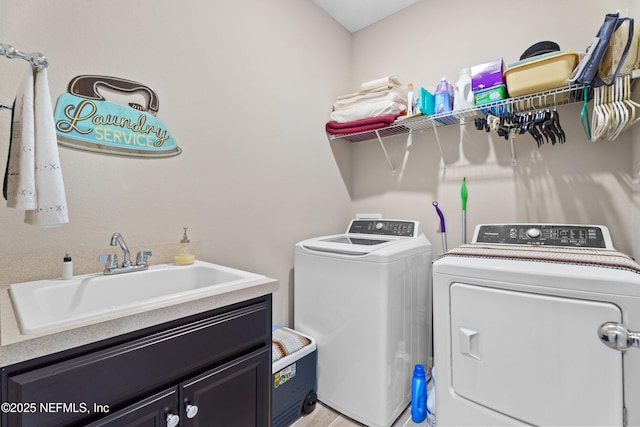 washroom with cabinets, sink, and washer and dryer