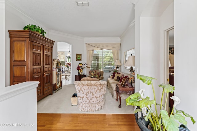 living room with light hardwood / wood-style flooring, crown molding, and a textured ceiling