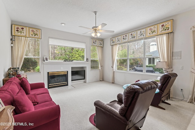 living room featuring ceiling fan, a textured ceiling, and light colored carpet