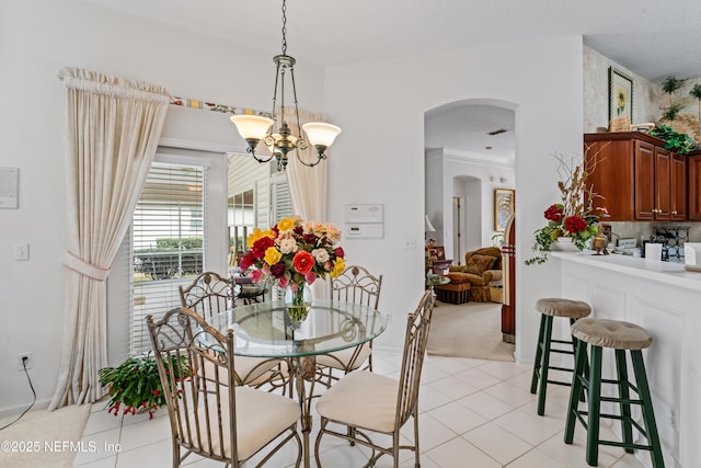 tiled dining space with a chandelier