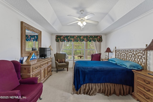 carpeted bedroom with ceiling fan, crown molding, a raised ceiling, and a textured ceiling