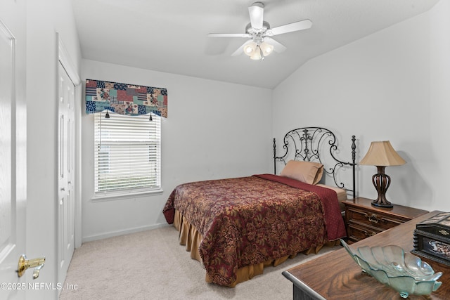 bedroom with light carpet, vaulted ceiling, ceiling fan, and a closet