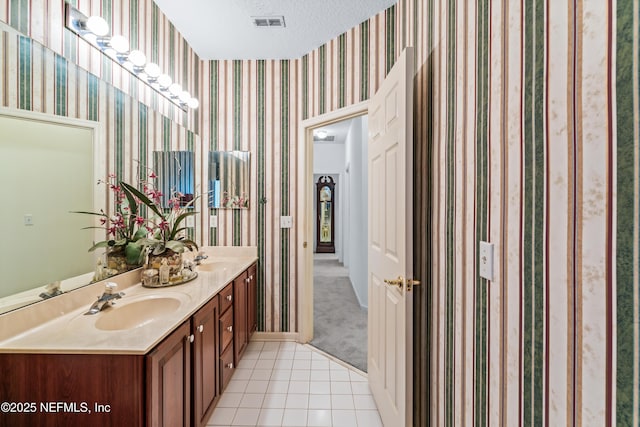 bathroom with vanity, a textured ceiling, and tile patterned floors