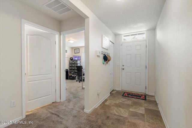 entrance foyer with a healthy amount of sunlight, carpet, and a textured ceiling