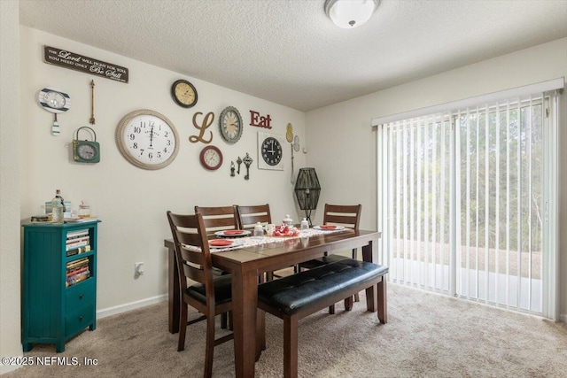 dining area with a textured ceiling and carpet flooring