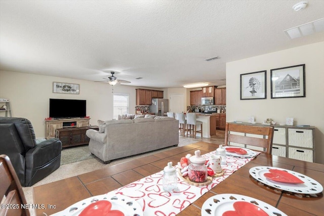 dining room with ceiling fan and a textured ceiling