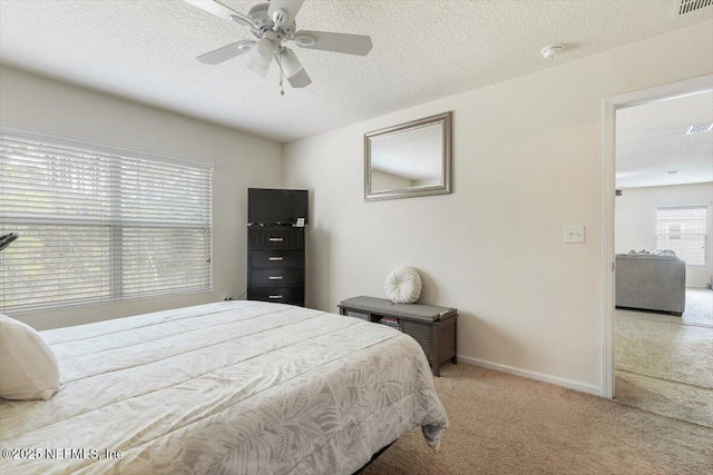 carpeted bedroom featuring ceiling fan and a textured ceiling