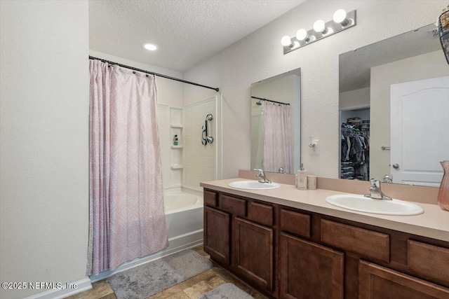 bathroom with vanity, shower / bath combination with curtain, and a textured ceiling