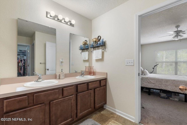 bathroom with vanity, ceiling fan, and a textured ceiling