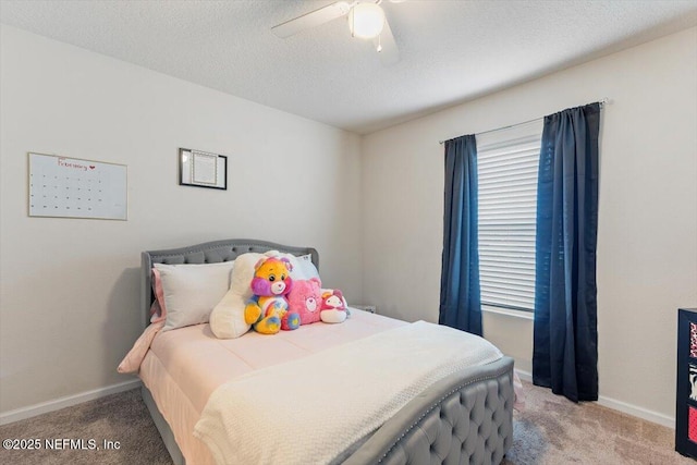 bedroom with ceiling fan, carpet flooring, and a textured ceiling