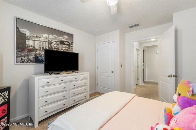 carpeted bedroom featuring ceiling fan and a textured ceiling