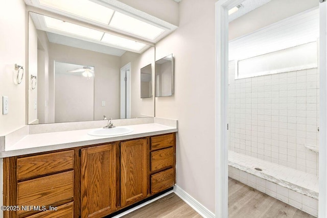 bathroom featuring vanity, wood-type flooring, and tiled shower