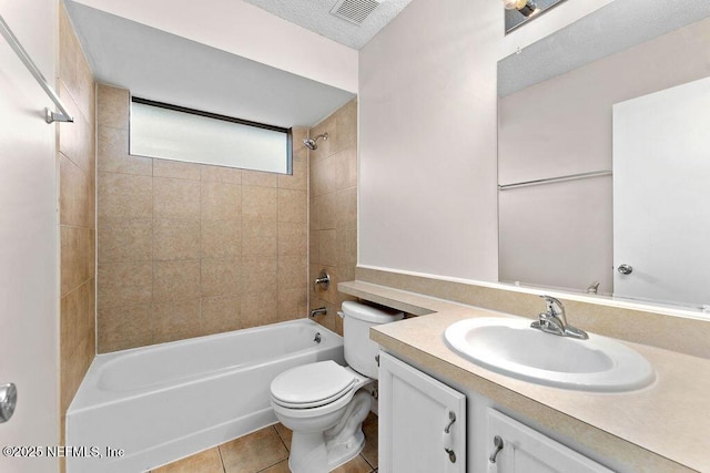 full bathroom with tiled shower / bath combo, vanity, toilet, tile patterned floors, and a textured ceiling