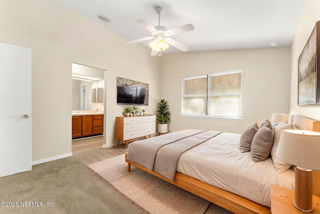 carpeted bedroom featuring ceiling fan, lofted ceiling, connected bathroom, and sink