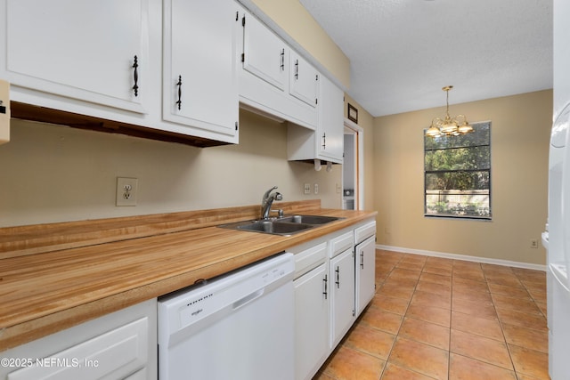 kitchen featuring white dishwasher, hanging light fixtures, white cabinetry, and sink