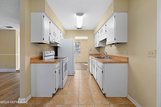 kitchen with white cabinetry, sink, white appliances, and light tile patterned floors