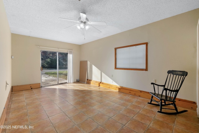 unfurnished room with a textured ceiling, ceiling fan, and light tile patterned flooring