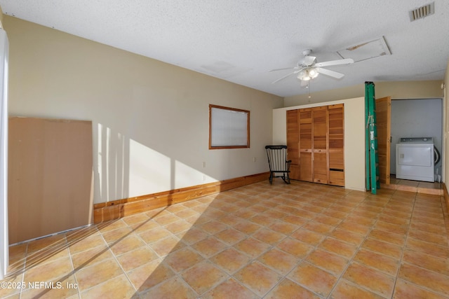 tiled empty room with ceiling fan, washer / dryer, and a textured ceiling