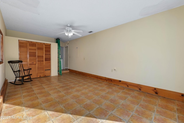 interior space with light tile patterned floors and ceiling fan