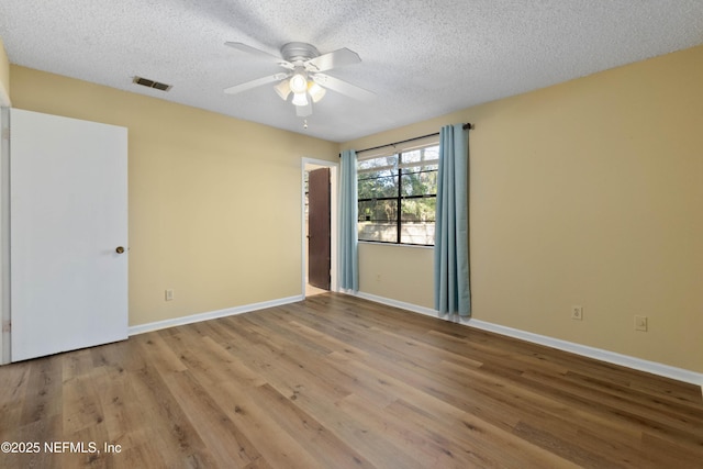 unfurnished room featuring ceiling fan, light hardwood / wood-style floors, and a textured ceiling