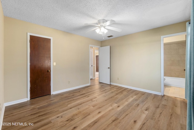 unfurnished bedroom with ceiling fan, connected bathroom, light hardwood / wood-style floors, and a textured ceiling