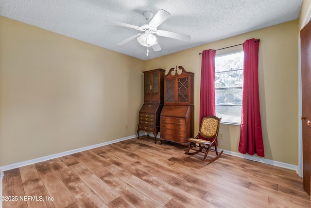 unfurnished room featuring ceiling fan, a textured ceiling, and light hardwood / wood-style floors