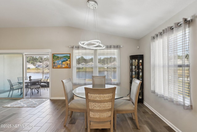 dining room with dark hardwood / wood-style flooring and vaulted ceiling