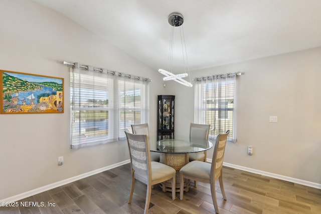 dining space with hardwood / wood-style flooring and vaulted ceiling