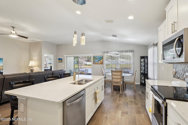 kitchen with white cabinetry, stainless steel appliances, decorative light fixtures, and sink