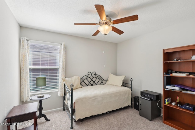 bedroom featuring ceiling fan, light colored carpet, and a textured ceiling