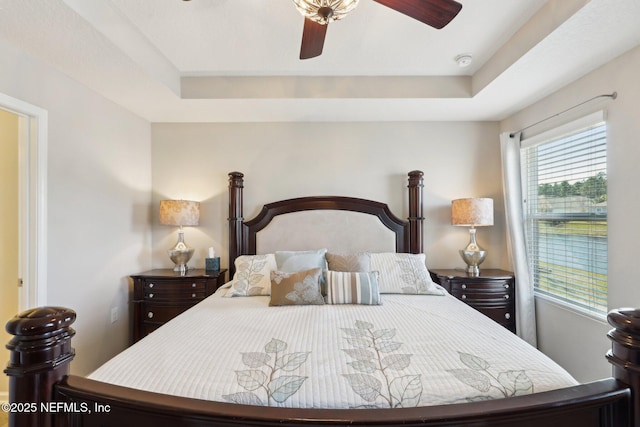 bedroom featuring a raised ceiling and ceiling fan