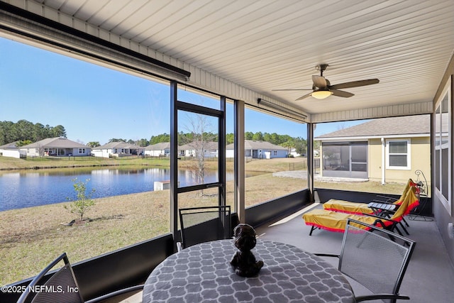 sunroom with a water view and ceiling fan