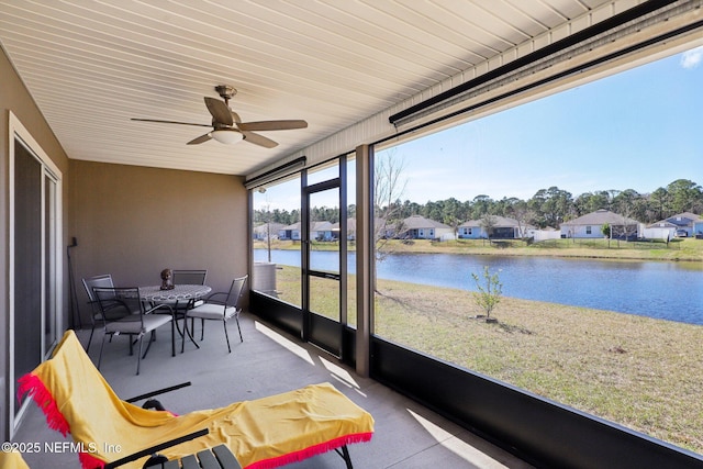 sunroom featuring a water view and ceiling fan