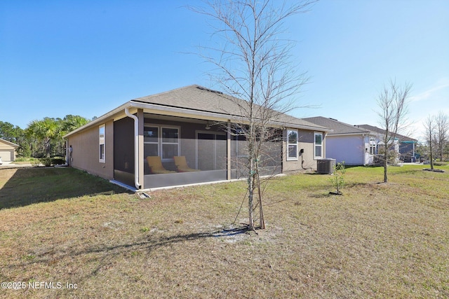 rear view of property with cooling unit, a yard, and a sunroom